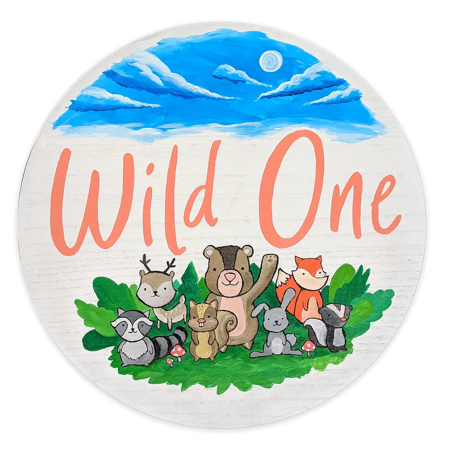 Round hand-painted nursery sign reading Wild One with woodland animals